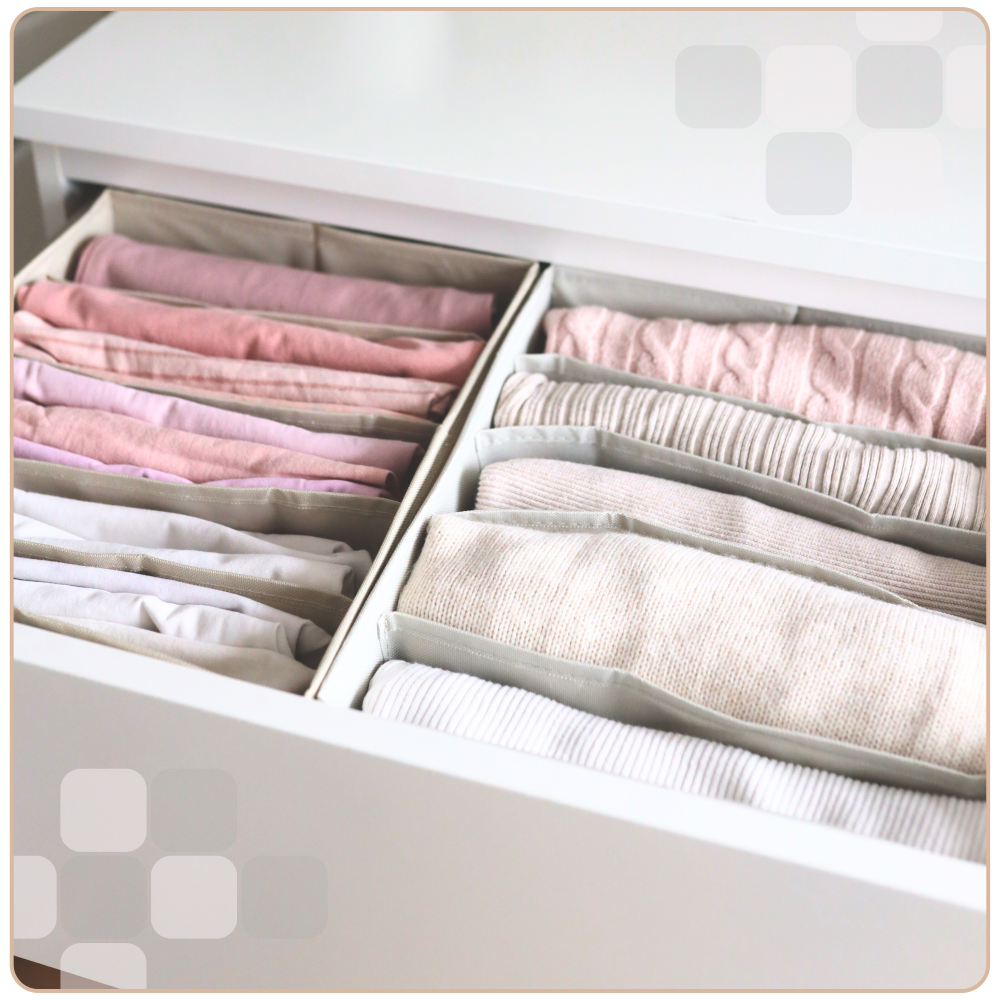 Dwa szare organizery na spodnie z 5 przegrodami, umieszczone w szufladzie i wypełnione ubraniami. Praktyczne rozwiązanie do utrzymania porządku w garderobie i efektywnej organizacji przestrzeni.